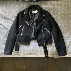 Mocka jacka  - Säljer denna ur snygga mocka jackan ifrån Nelly i stl 34. Jag köpte den begagnat men den var för liten för mig. Det är lite små fix på den och en ögla som saknas till bandet. Men inget som inte går att fixa!! Köpte den för 270 så säljer den för 170 kr. 