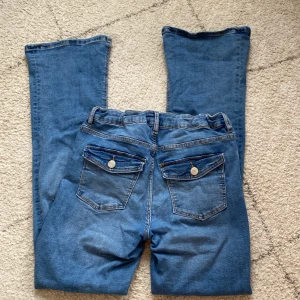2000s bootcut jeans - Ett par blåa jeans från Gina tricot för 350kr o säljer för 200kr. Storlek 158, svin coola fickor och bootcut. Midjemått: 79 runt midjan. Innerbenslängd: 70. Lite stretch i midjan.