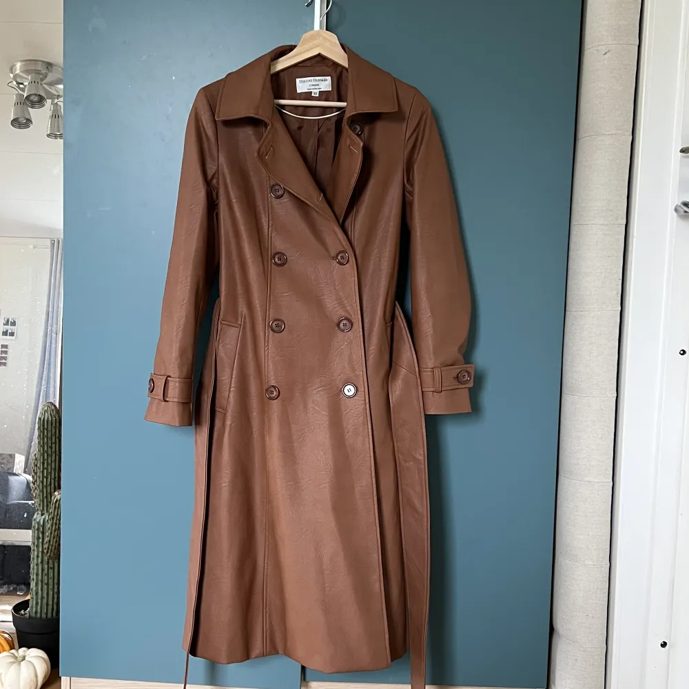 Helene Berman- brun trenchcoat i läderimitation. Sälja på ASOS för 1200kr och är slutsålt på hemsidan. Har bara använts en gång och är som ny. Sitter super snyggt på och perfekt att ha en tjocktröja eller hoodie under. . Jackor.