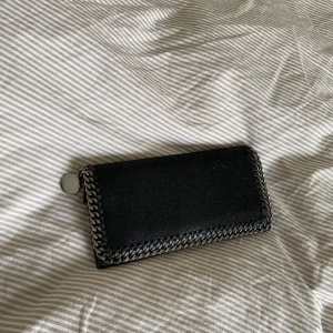 Stella Mccartney Plånbok - Svart plånbok från Stella Mccartney. Går även att ha som en fin-väska. Kommer med tillhörande kvitto, tags och dustbag + kartong. Perfekt skick! Inköpt i deras numera nedlagda butik i Stockholm.