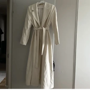 Vit Trenchcoat - Massimo Dutti - Vit trenchoat som aldrig har använts. Den har knappar för att knappa på päls. Den är liten i storleken så skulle säga 38/40 i passform👍🏼den är mycket efterfrågad, köpt för 649kr men säljer den för 299kr!