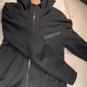 Nike tech - En svart Nike tech i storlek S. Säljs pågrund av att den bara samlar damm i garderoben. Väldigt sparsamt använd. Vid frågor och annat så är det bara att höra av sig! Pris kan diskuteras!
