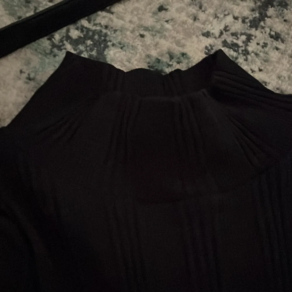 En svart ribbad tröja från Gina tricot. Strl Xs och knappt använd med inga skador. Med slits i armarna.. Toppar.