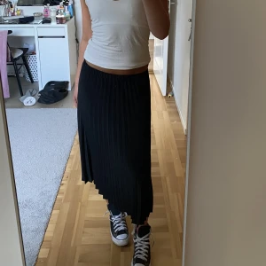 Långkjol - Svart långkjol som är lite ribbad liknande. Den är från Gina och är i ett väldigt bra skick!! Den är i storlek 32 men passar både mindre och större storlekar än de!