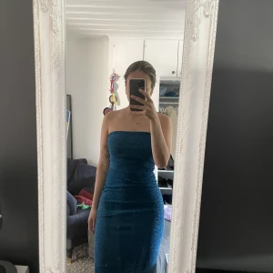 Tub-klänning i blåglitter - Fin klänning. Slits i bak. Använd fåtal gånger därav i fint skick! 