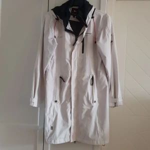 Jacka  - Tunn, vit, vindjacka. 