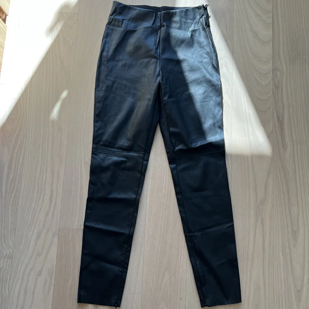 Mint condition, barely worn, black leather pants with detailing. . Jeans & Byxor.