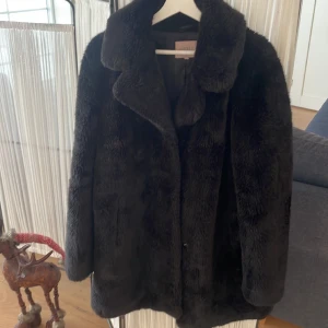 Svart pälsjacka - Fuskpäls, en knapp är borta,  lite slitach vid armbågarna (men inget som e märkvärdigt.