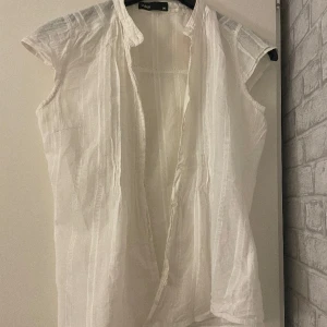 Vit blus - Söt vit blus som är oanvänd. Fina detaljer på men saknar tyvär en liten knapp näst längst ned men det är inget som syns.