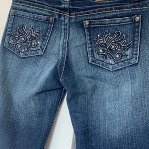 lowrise jeans med detaljer  - Snygga jeans med coola detaljer på fickorna, lowrise. Originellt vintage från 2000s