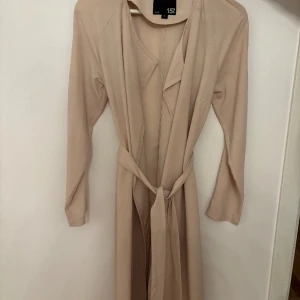 Trenchcoat  - Beige lång trenchcoat. Ordpris 200kr