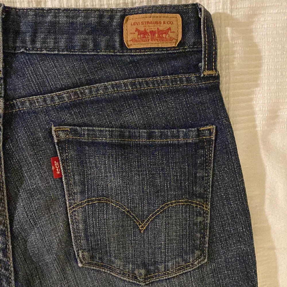 Säljer mina ursnygga jeans från Levis i modellen ”mid rise straight” 552. Jeansen har ett hål och är lite slitna längst upp vid låren, men det är inget som märks när man har på dem. . Jeans & Byxor.