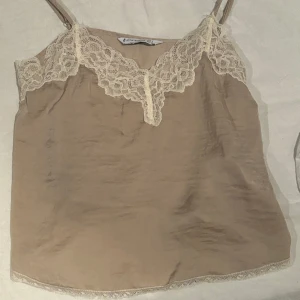 Beige linne - Oanvändt beige spetslinne med justerbara axelband från stradivarius i storlek S.
