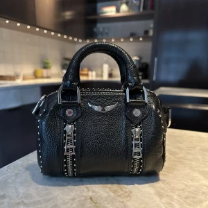 Zadig väska - Här är en supersnygg svart zadigväska med nitar. Den är i skinn  och har ett justerbart strap. Den är rymlig för sin storlek och passar till mycket. Den är i ett jättebra skick och köpt för ca 3800kr❤️skriv om ni vill ha äkthetsbevis❤️