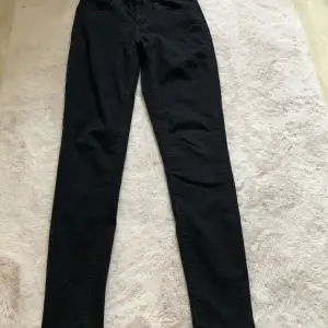Svarta skinny jeans från Levi’s. Mönster på fickorna.