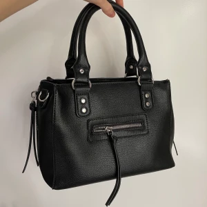 Väska - Säljer denna supersöta väska från Nelly! Mycket fint skick, knappt använd!😊 Ca 25 cm bred och 18 cm hög. Köparen står för eventuell frakt!