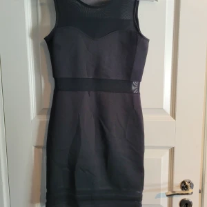 Svart klänning  - Svart figursydd klänning Oanvänd 