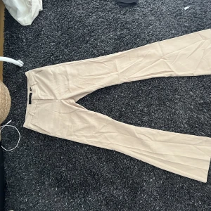 Lågmidjade kostymbyxor - Ett par kostymbyxor med låg midja och utsvängda ben 