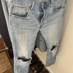 Levis 501 - Egendesignade 501or, hål fram på benen, på backfickan och slitning på fickorna. Kan skicka fler bilder. Ljus tvätt. Strechvarianten så den är väldigt bekväm. Säljer för att jag börjat köra ännu vidare. Tänker mig 250kr
