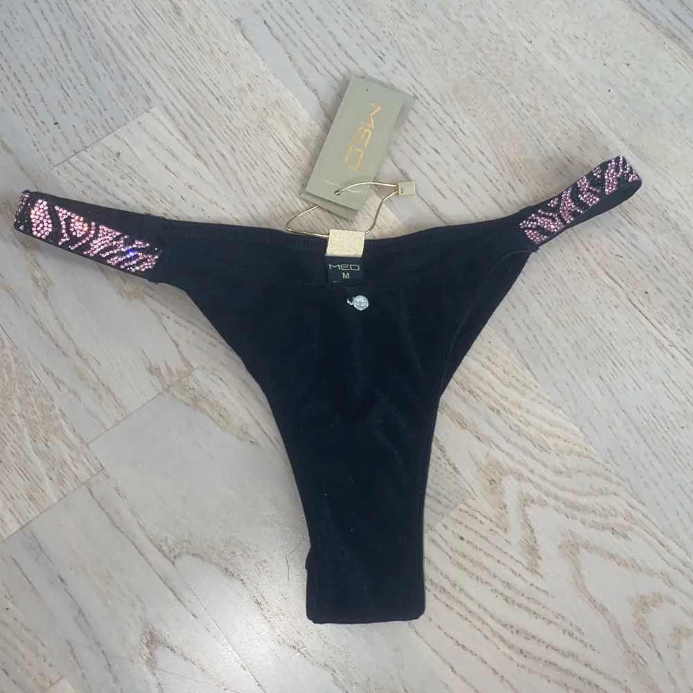 En superfin bikini underdel med rosa glitter Mönster på sidorna,  i storlek M, köpt i en känd bikini affär i Grekland (MED) , nypris ca 280 kr, helt oanvänd, passar även S💘. Övrigt.