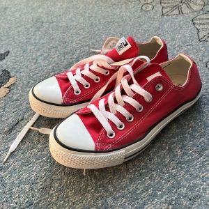 Röda Converse all star low top  - Sparsamt använda röda Converse all star low top, storlek 39. Härliga sommarskor. Ett par slitningar i tyget på höger sko  *Håller på att flytta så köp gärna så snart som möjligt* 