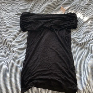 Svart off shoulder top - Det är en svart off shoulder top som ör helt oanvänd för billigare pris!