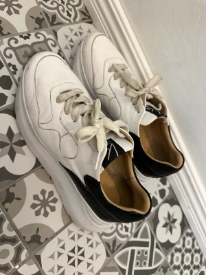 Sneakers  - Storlek 39. Äkta läder. Behöver sig en tvätt. Annars i fint skick.
