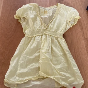 Gul sommrigtopp  - En jättefin gulsommrig topp med lite spets. Är lite see-through men det kan vara fin med på stranden. Den är också lite gulare i verkligheten 