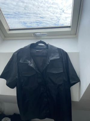 Skinn skjorta - Svart skinnskjorta från Gina tricot i storlek XL. Blir som en oversized, passar mig som är 177 cm. Gratis frakt via tise 
