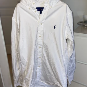 Ralph Lauren vit skjorta - Vit skjorta från Ralph Lauren i storlek 16. Köpt förra sommaren och sparsamt använd med inga slitningar eller skador! Passar mig som har XS/S