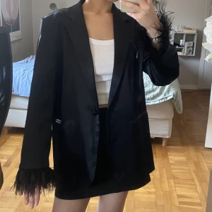 Siden kavaj med fjäder detaljer  - Superfin kavaj i ”siden” med fjäder detaljer på ärmarna. Endast använd 1 gång. Storlek M, men sitter snyggt oversized på mig som vanligtvis brukar ha S. 