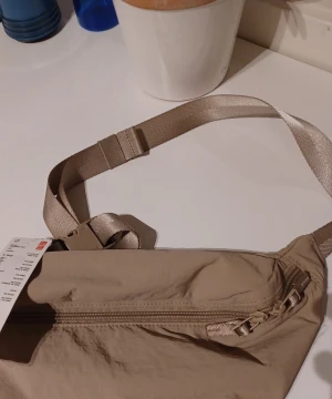 Uniqlo bag - Aldrig använd Uniqlo axel väska. Helt ny med lappar. Var en presnet som köptes utomlands.