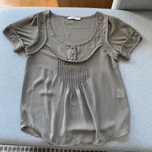 Fin ljusgrön blus  - Söt blus med genomskinligt tyg och knappar vid bysten. För liten för mig så inte så använd. 