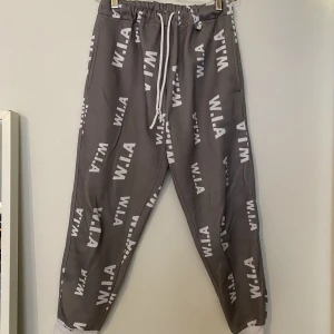 W.I.A Collections FLOOD SWEATPANTS - W.I.A Collections FLOOD SWEATPANTS  Grå med vitt text   Kedja också inkluderad   Storlek dam S  Använda men i bra skick 