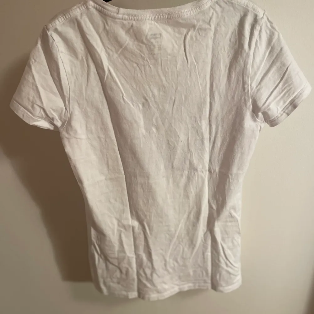 Vit Levis T-shirt med snyggt unikt tryck där fram🌆 Den sitter ganska tight i modellen💗. T-shirts.