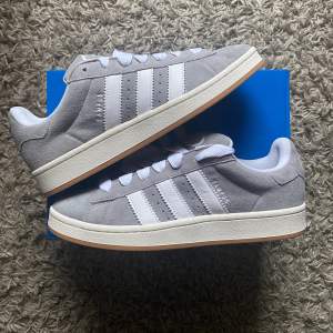 Säljer dessa snygga ljusgråa Adidas Campus 00s ”Grey Gum”. Helt nya och oanvända, lappar finns kvar samt kvitto från Adidas. Medföljer även gråa snören. Passa på o köp en tidig julklapp 🎄