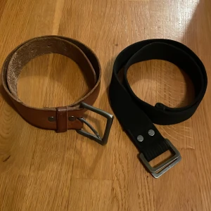 Två bälten - Vintage bälte i brunt läder och bälte i svart tyg. Bältena är 80cm långa men passar för midjor under 70💗
