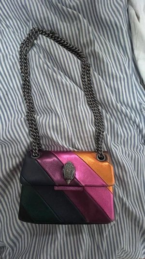 Kurt geiger väska  - Säljer min fina regnbågiga Kurt väska. Säljer den för att den inte kommer till andvändning så mycket. Den är lite sliten men man ser knappt det.