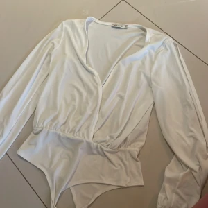 Vit body med öppna armar  - Vit body från Nelly med öppna armar 