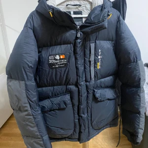 Sail Racing Antarctica Expedition Jacket strl M - Marinblå Sail Racing dun vinterjacka.  Använd mestadels i bilfärd . Ett litet hål på armen ( se sista bild ) annars i toppen skick . 