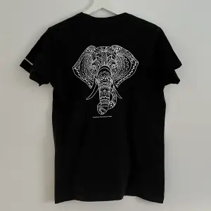 Svart t-shirt med ett coolt tryck på ryggen i form av en elefant. T-shirten är i fint skick. 