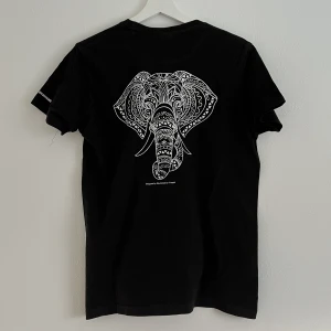 T-shirt  - Svart t-shirt med ett coolt tryck på ryggen i form av en elefant. T-shirten är i fint skick. 