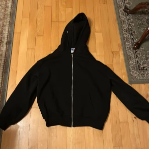 Oversized ziphoodie i svart färg och storlek M - Det är riktigt kvalle på materialet. Den är oanvänd och passar alla som har storlek M i vanliga kläder.