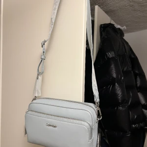 Calvin Klein Must Camera Bag Unisex - Axelremsväska  - Helt Ny: Calvin Klein Must Camera Bag Unisex - Axelremsväska, Helt slutsåld online 