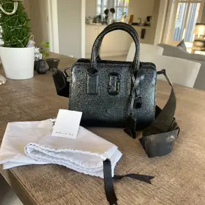 Säljer min Marc Jacobs big shot väska i färgen svart. Väskan är knappt använd och har inga fläckar eller skador. Nypris 5099. Fler bilder kan skickas vid önskan. Väskan ligger ute på flera sidor.