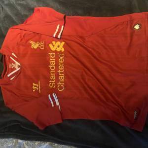En Liverpool tröja som är för liten och inte används sponsor texten är sliten men annars i helt skick🥊🎈 för för frågor m.m