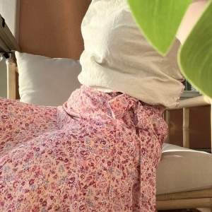 Jättefin rosa, blommig kjol från märket ”Clara Paris” i nyskick!! Kjolen har inbyggda shorts då den är rätt så kort. Stl S/M men passar en Xs/S då den är liten i storleken.