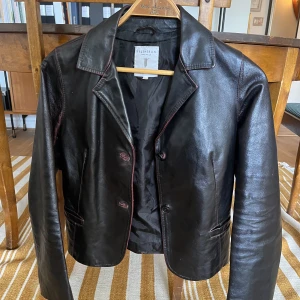 Skinnjacka  - Mörkbrun/svart skinnjacka som är i storlek Small/Medium. Ej längre modell. 
