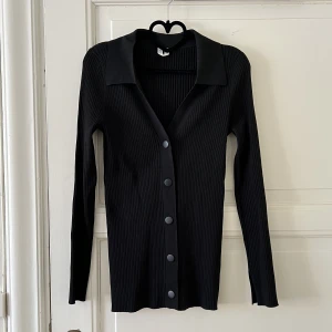 Arket topp med krage  - Fin ribbad topp från arket med krage och tryckknappar. 