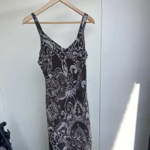 Mörkbrun mönstrad klänning med mönster längs benen